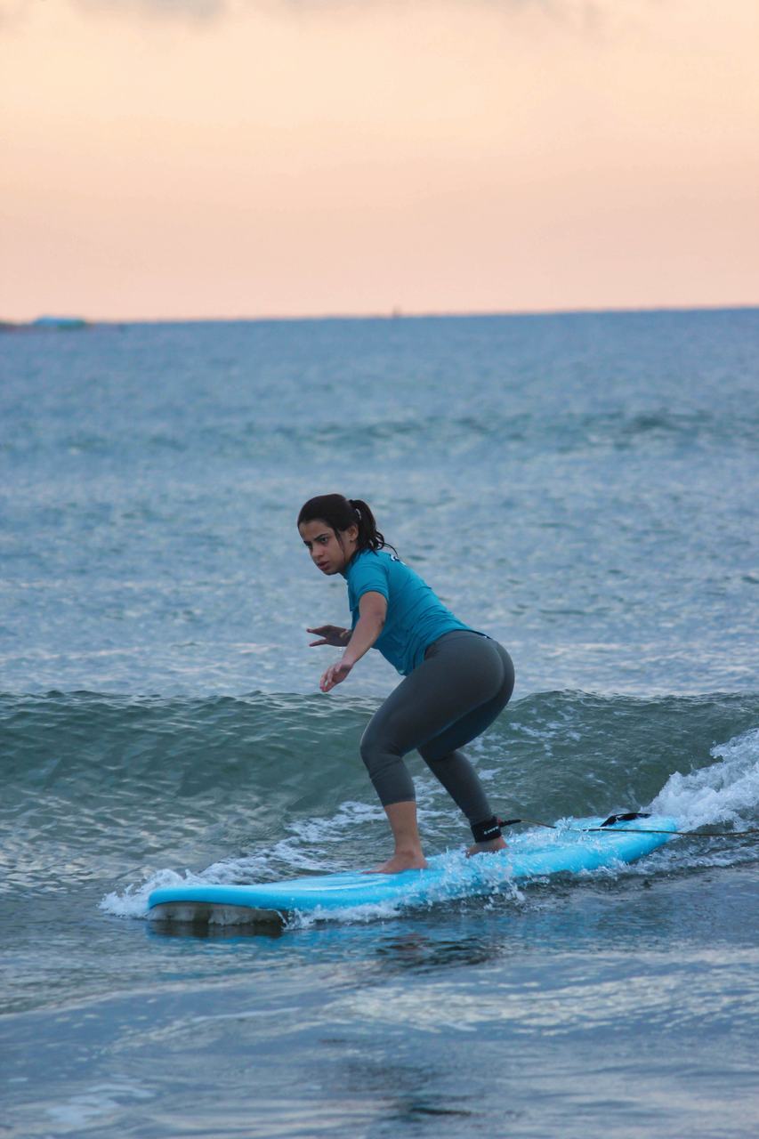 Student riding a small wave at first light
