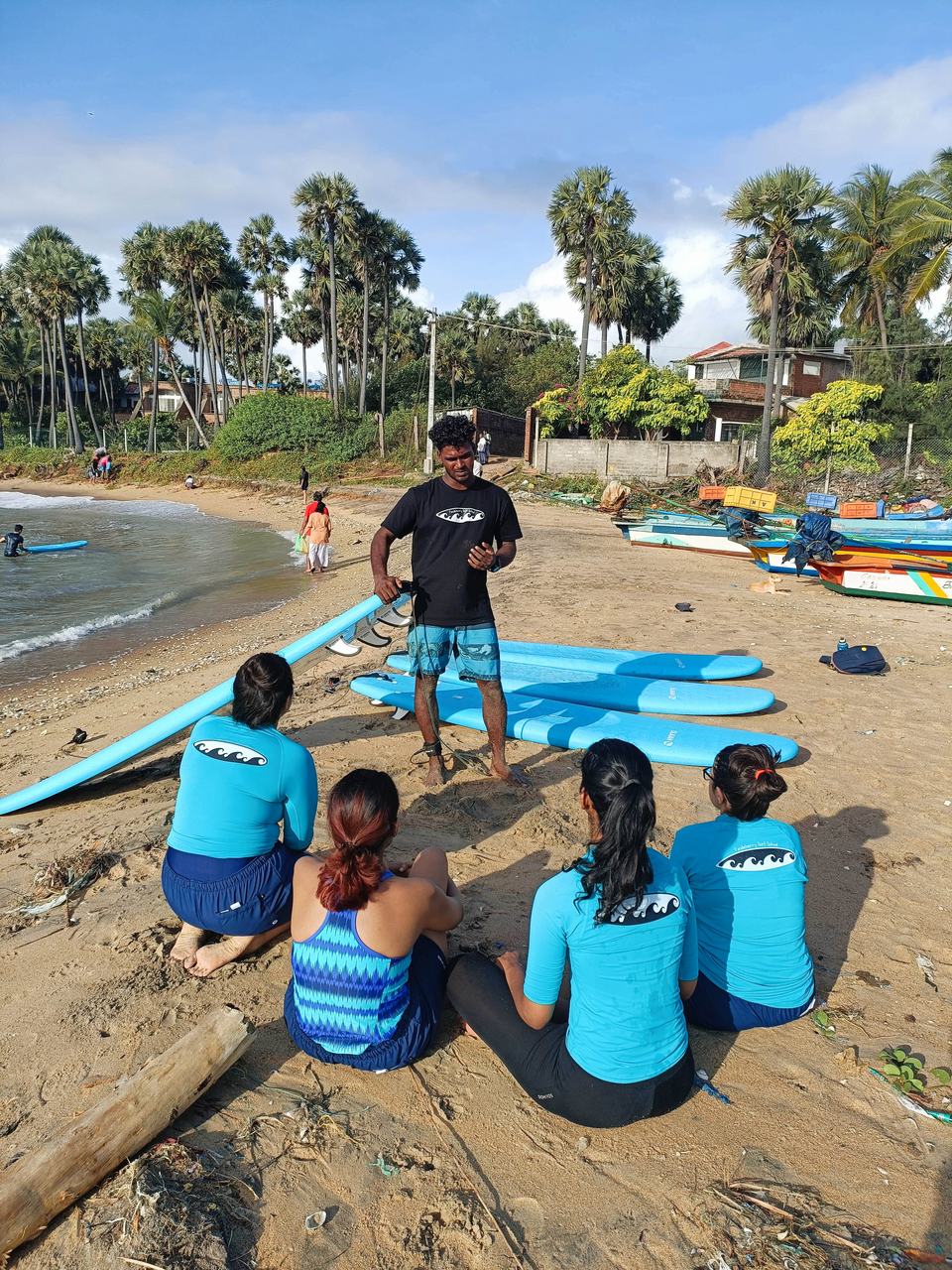 Beach lesson with students seated around the instructor